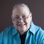 Elder Barbara Lundquist, a white woman, smiles at the camera