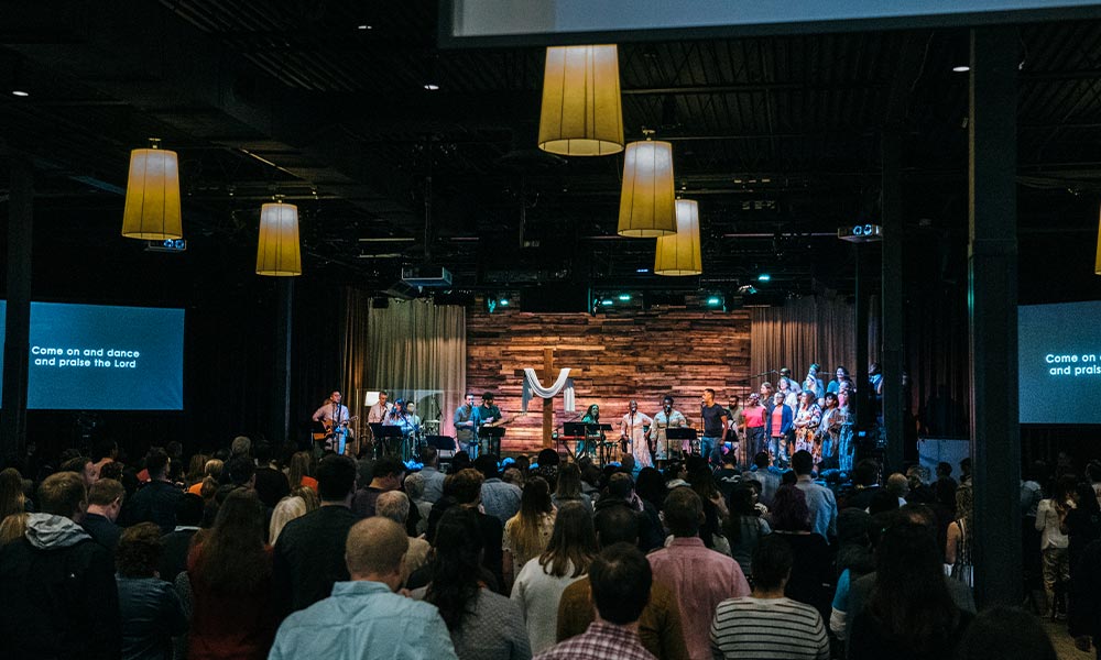 This is a photo of a full sancutuary during an Easter service at Quest. The stage is full of members of the Worship Team.
