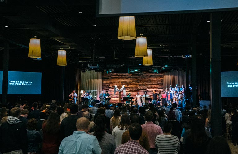 This is a photo of a full sancutuary during an Easter service at Quest. The stage is full of members of the Worship Team.